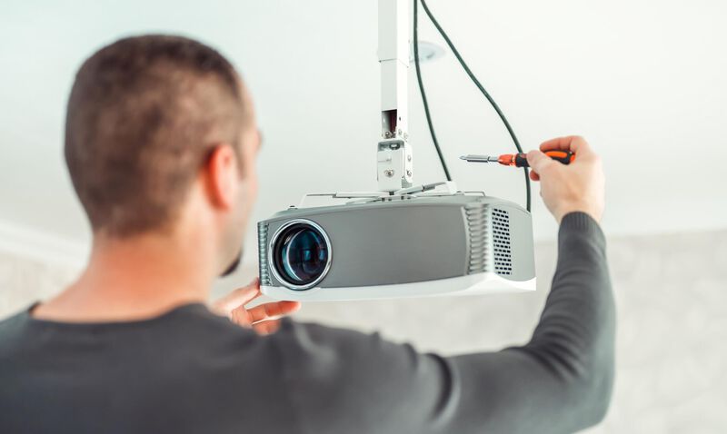 Man installing hanging ceiling projector